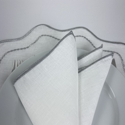Guardanapo branco com borda cinza sobre prato branco
