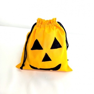 Saco amarelo com rosto de abóbora de Halloween