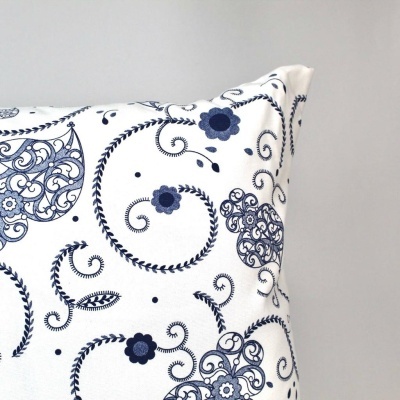 Almofada branca com padrão azul de flores e arabescos