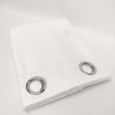 Cortina branca dobrada com padrão geométrico e ilhós prateados