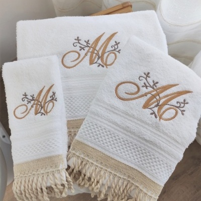 Conjunto de toalhas brancas com bordado dourado e franjas bege