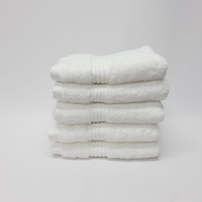 Toalhas brancas empilhadas de tecido felpudo com faixas texturizadas