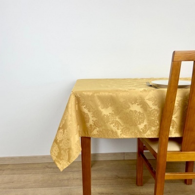 Mesa com toalha amarela dourada e cadeira de madeira