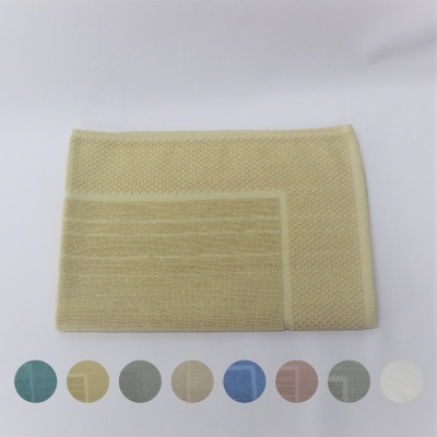 Toalha de banho amarelo claro em algodão com textura em padrão de ondas e losangos