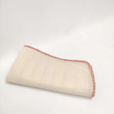 Guardanapo de tecido creme com borda rosa floral dobrado