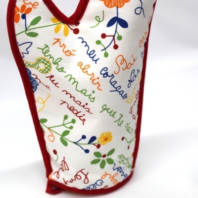 Capa para garrafa colorida com padrão de flores e texto em tecido branco com bordas vermelhas