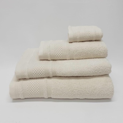 Conjunto de toalhas bege claras com padrão geométrico empilhadas