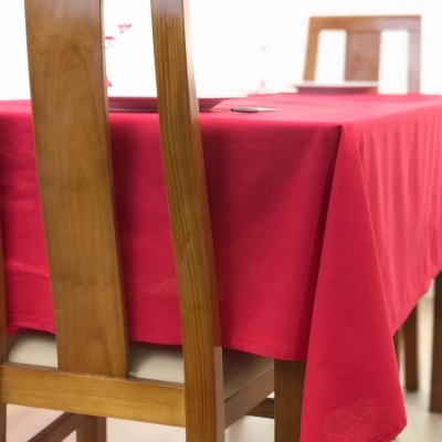 Mesa de jantar com toalha vermelha e cadeira de madeira clara