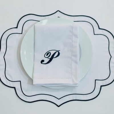 Jogo americano branco com bordas pretas e guardanapo branco com letra P bordada em preto