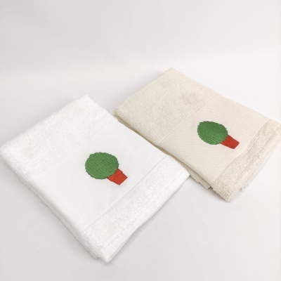 Duas toalhas de banho em branco e bege com bordado de árvore