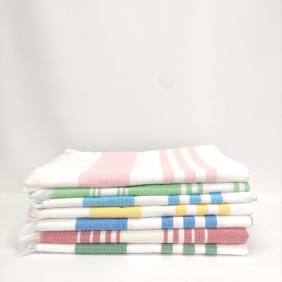 Pilhas de toalhas de tecido branco com listras coloridas e franjas