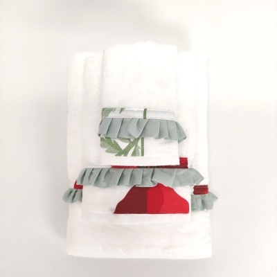 Toalhas brancas com bordados coloridos e detalhes em tecido plissado