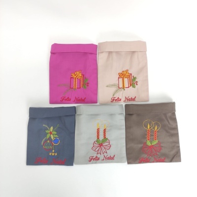 Cinco saquinhos de tecido com bordados natalícios e texto 'Feliz Natal'