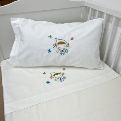 Jogo de cama infantil com bordado de personagem num berço branco