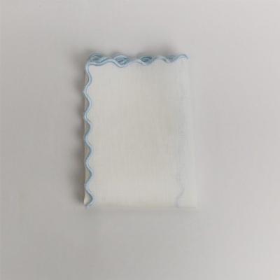 Toalha ou pano branco com borda azul ondulada sobre fundo branco