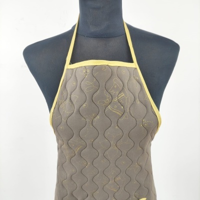 Avental castanho com padrão ondulado e detalhes amarelos em manequim preto