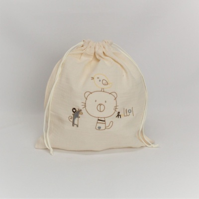 Mochila de pano creme com cordões e desenho bordado de urso, pássaro e macaco.