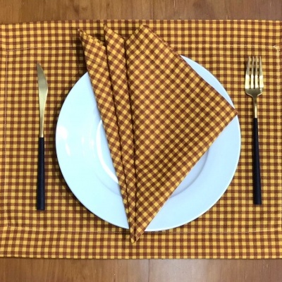 Conjunto de mesa xadrez castanho, prato branco e talheres preto e ouro