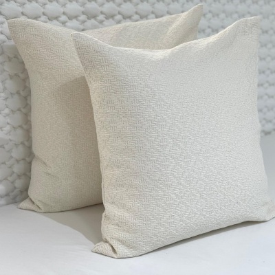 Duas almofadas brancas quadradas com textura geométrica