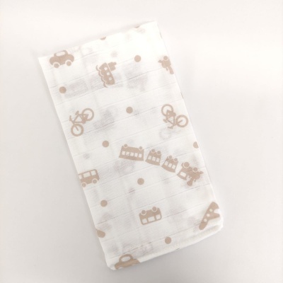 Fralda de tecido branco com padrão castanho de bicicletas, carros e edifícios.