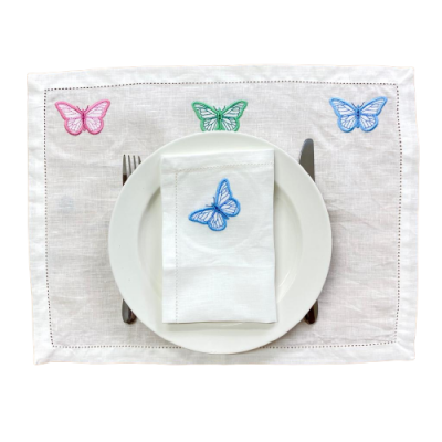 Jogo americano branco com bordados de borboletas coloridas, prato branco, garfo e faca