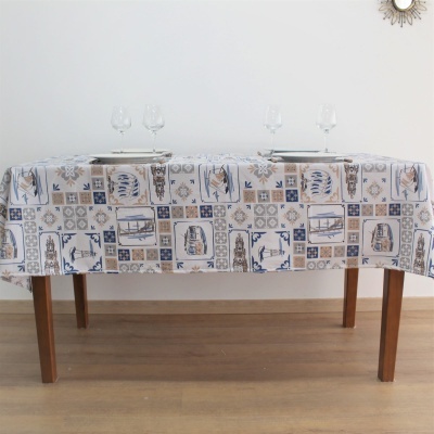 Toalha de mesa azul, bege e branco com padrão de azulejos sobre mesa de madeira