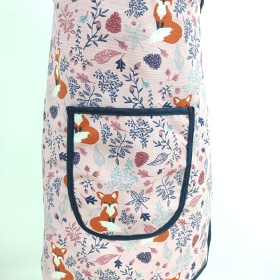 Avental rosa com padrão de raposas e folhas e bolso preto