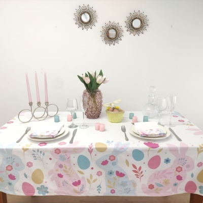 Mesa decorada com toalha estampada, flores e castiçal com velas
