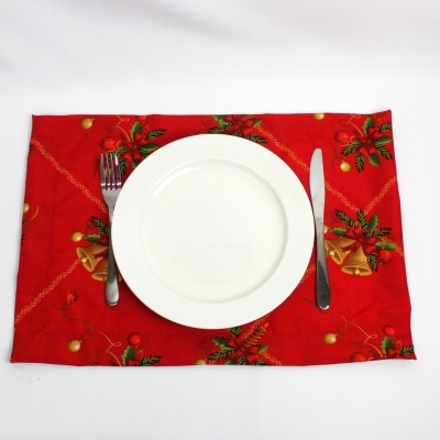 Conjunto de jantar num individual vermelho com motivos natalícios