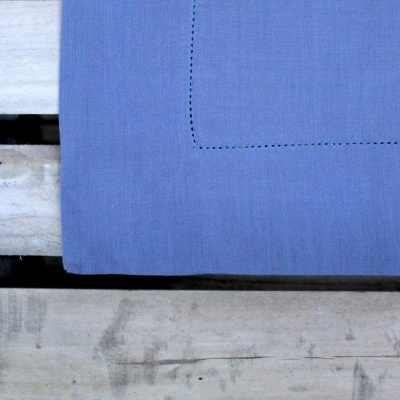 Colchão ou tapete cinzento com costura sobre madeira natural