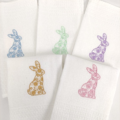 Cinco toalhas brancas com bordados coloridos de coelhos sentados