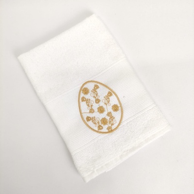 Toalha branca com bordado dourado de flores num oval