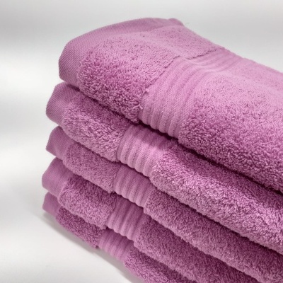 Conjunto de cinco toalhas cor de rosa em pilha, tecido felpudo com faixas horizontais