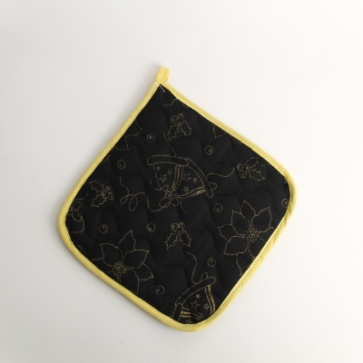 Pega de cozinha preta com bordas amarelas e padrão dourado bordado