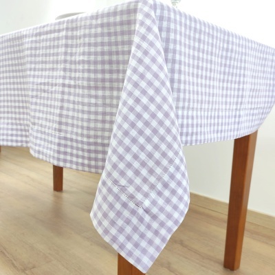 Toalha de mesa xadrez lilás e branco numa mesa de madeira