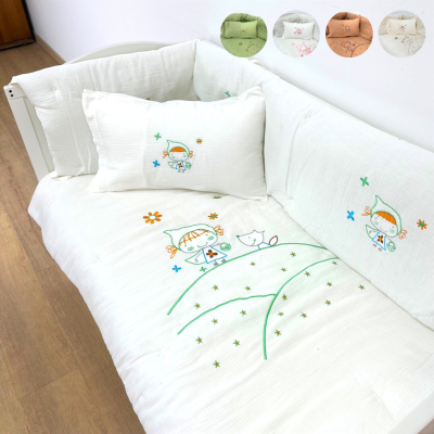 Cama ou sofá branco com proteção acolchoada decorada com bordados coloridos e almofadas de tecido semelhante