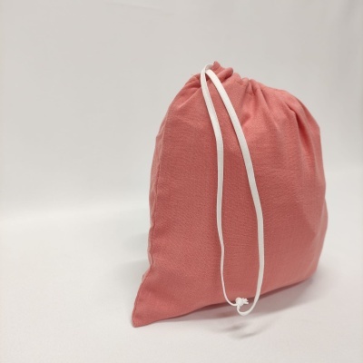 Saco tecido rosa com cordão branco em fundo branco