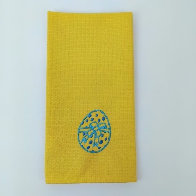 Guardanapo amarelo com bordado azul de ovo com laço
