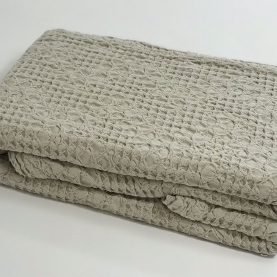 Cobertor cinza claro com padrão quadriculado dobrado