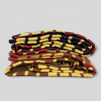 Duas mantas dobradas com padrão xadrez em cores amarelo, vermelho, azul e castanho