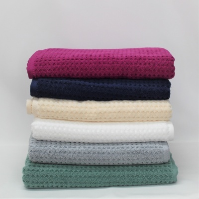 Pilhas de toalhas de várias cores com padrão texturizado em relevo