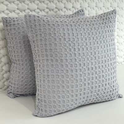 Duas almofadas cinzentas com padrão quadrado em relevo
