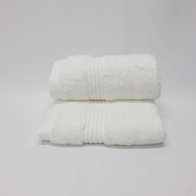 Duas toalhas brancas dobradas com padrão liso e linhas decorativas