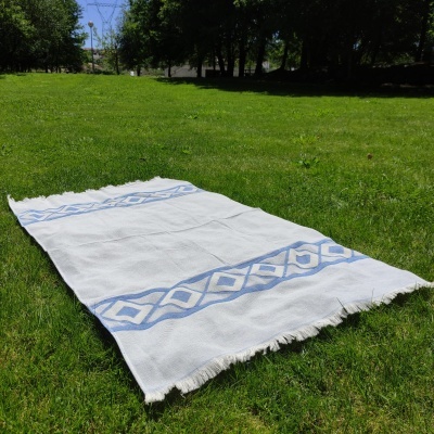 Tapete branco com padrão azul sobre relva