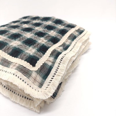 Pano de tecido xadrez azul e branco com renda e franjas dobrado