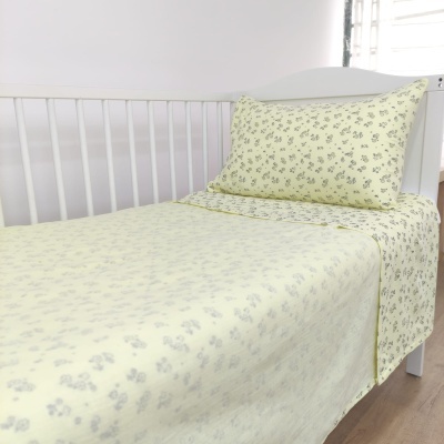 Conjunto de cama para berço amarelo claro com padrão de pequenas flores cinzentas