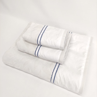 Três toalhas de banho brancas com riscas azuis empilhadas em fundo branco