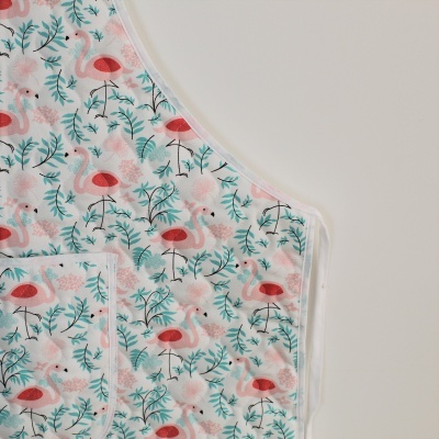 Pano branco com padrão de flamingos cor-de-rosa e folhas verdes