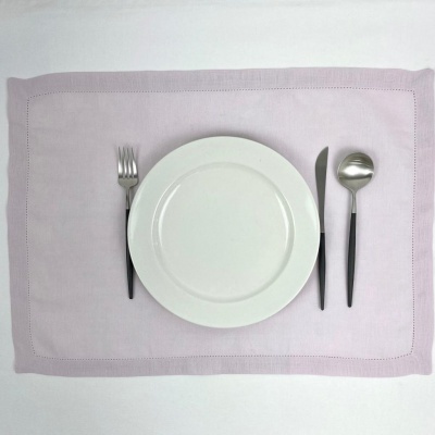 Prato branco redondo com talheres de cabo preto em individual lilás