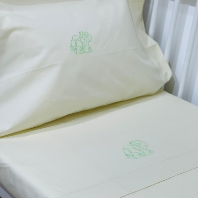 Lençóis creme para cama de bebé com bordados verdes de elefantes